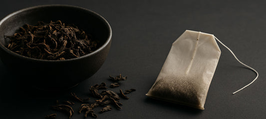 Loose leaf tea beside a filled paper tea bag