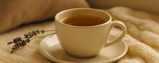 Herbal tea beside dried lavender on a soft blanket