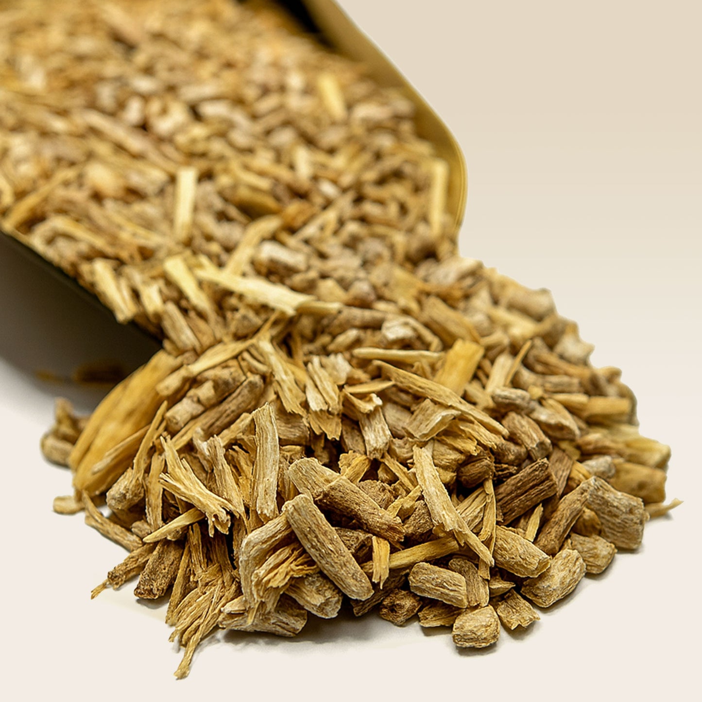 Dried Ashwagandha Root spilling out of a brown paper bag on a light background