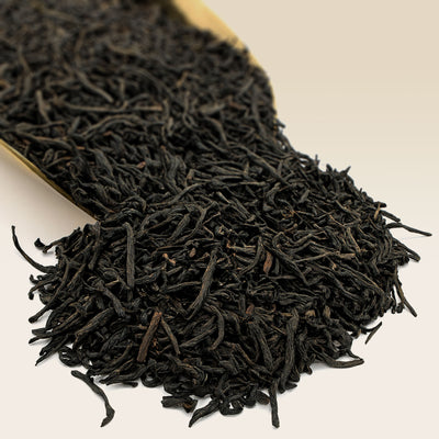 Close-up of Chinese black Keemun tea leaves on a beige background