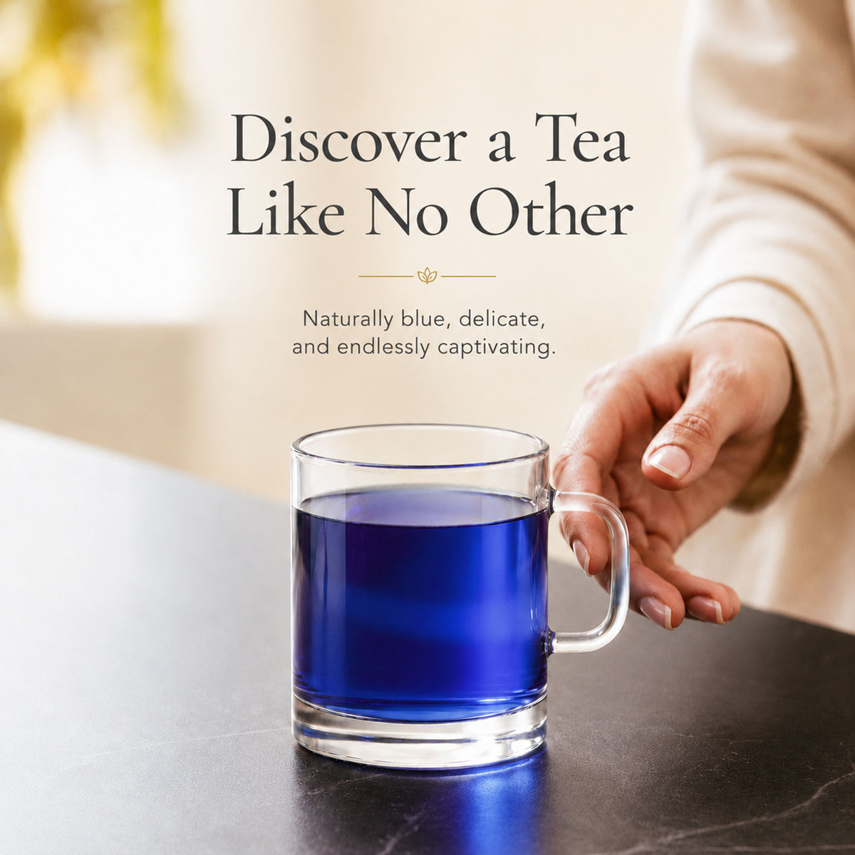 Person holding a glass cup of vivid blue butterfly pea flower tea
