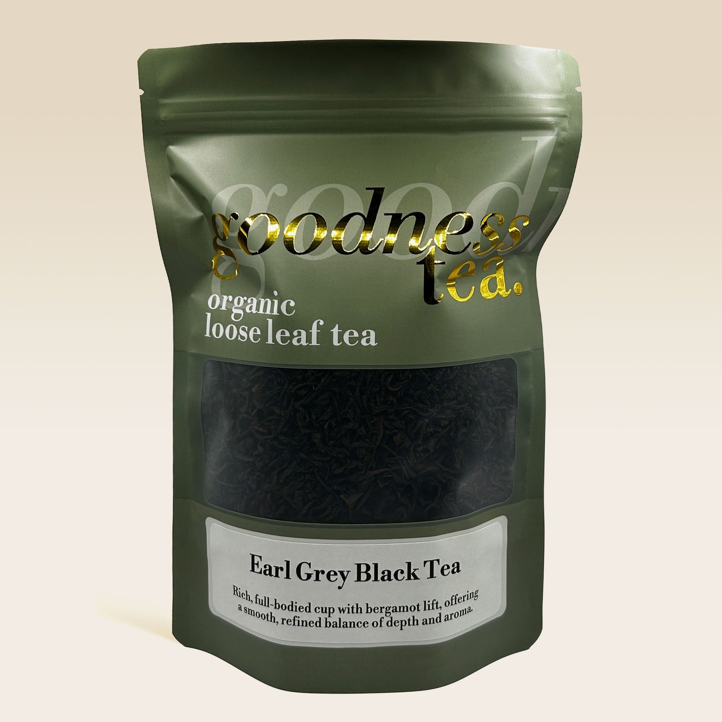 Green package of organic loose leaf tea with 'goodness tea' branding on a beige background