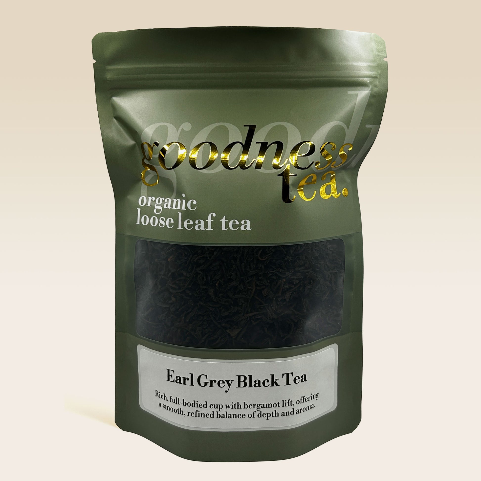 Green package of organic loose leaf tea with 'goodness tea' branding on a beige background