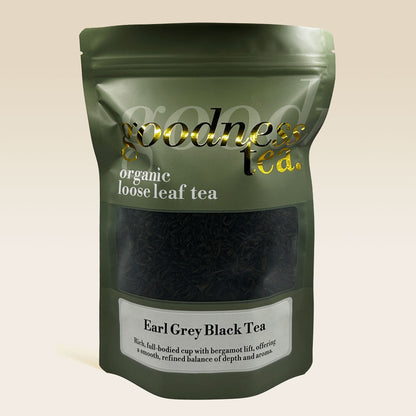 Green package of organic loose leaf tea with 'goodness tea' branding on a beige background
