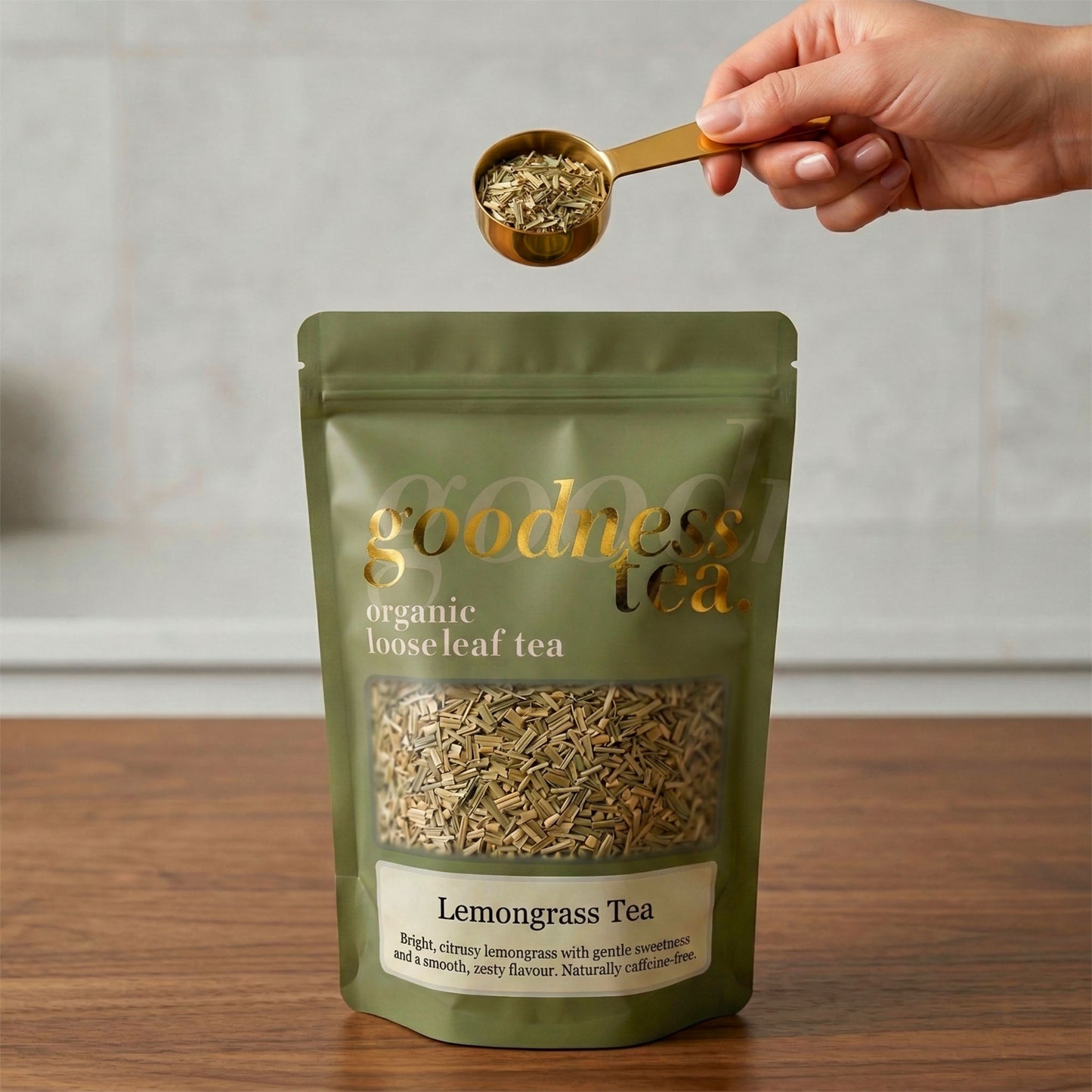 Goodness Tea package with a hand holding a scoop of lemongrass tea.