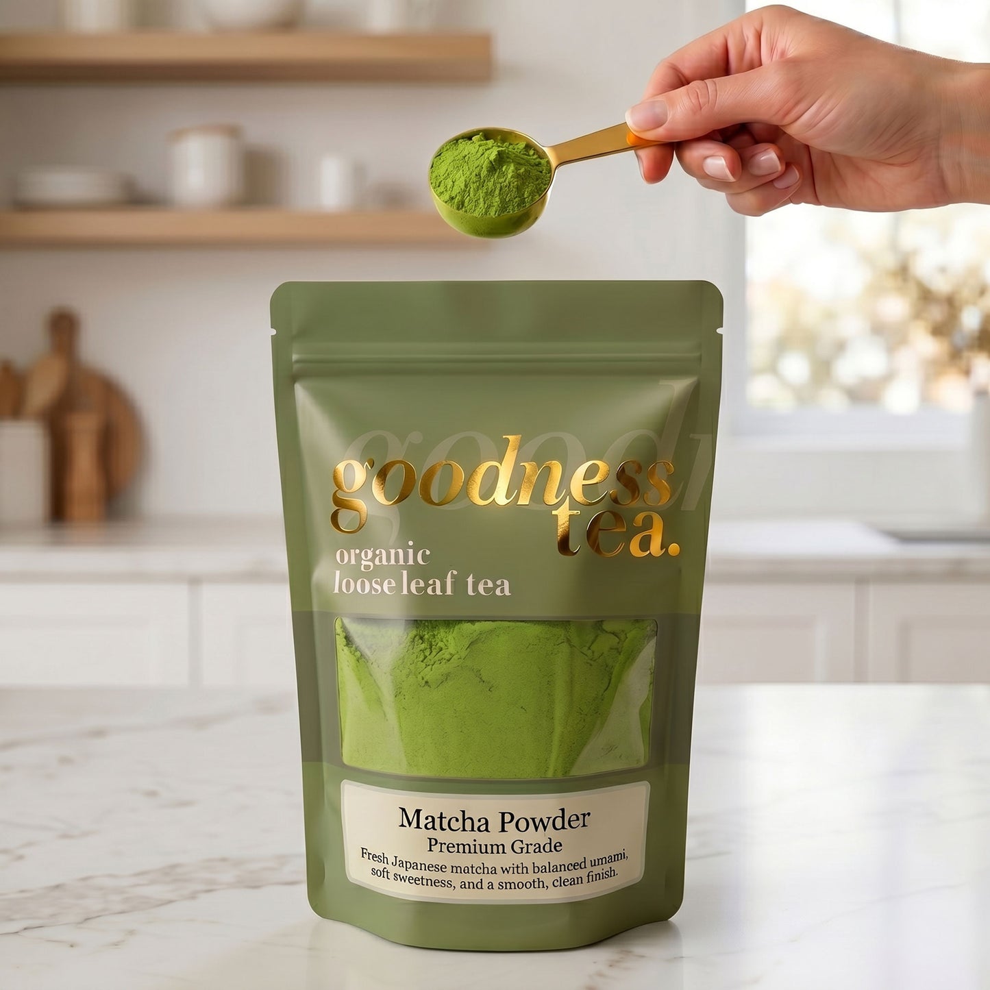 Goodness Tea matcha powder package with a spoonful of matcha powder above it.