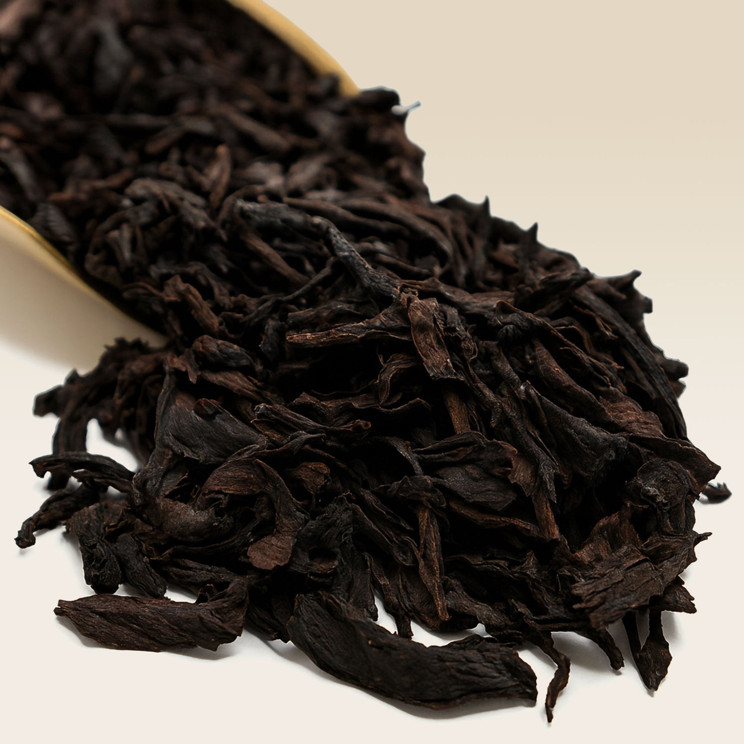 Close-up of Oolong tea leaves on a light beige background