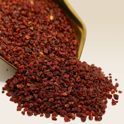Rose Hip Tea in a gold scoop on a beige background