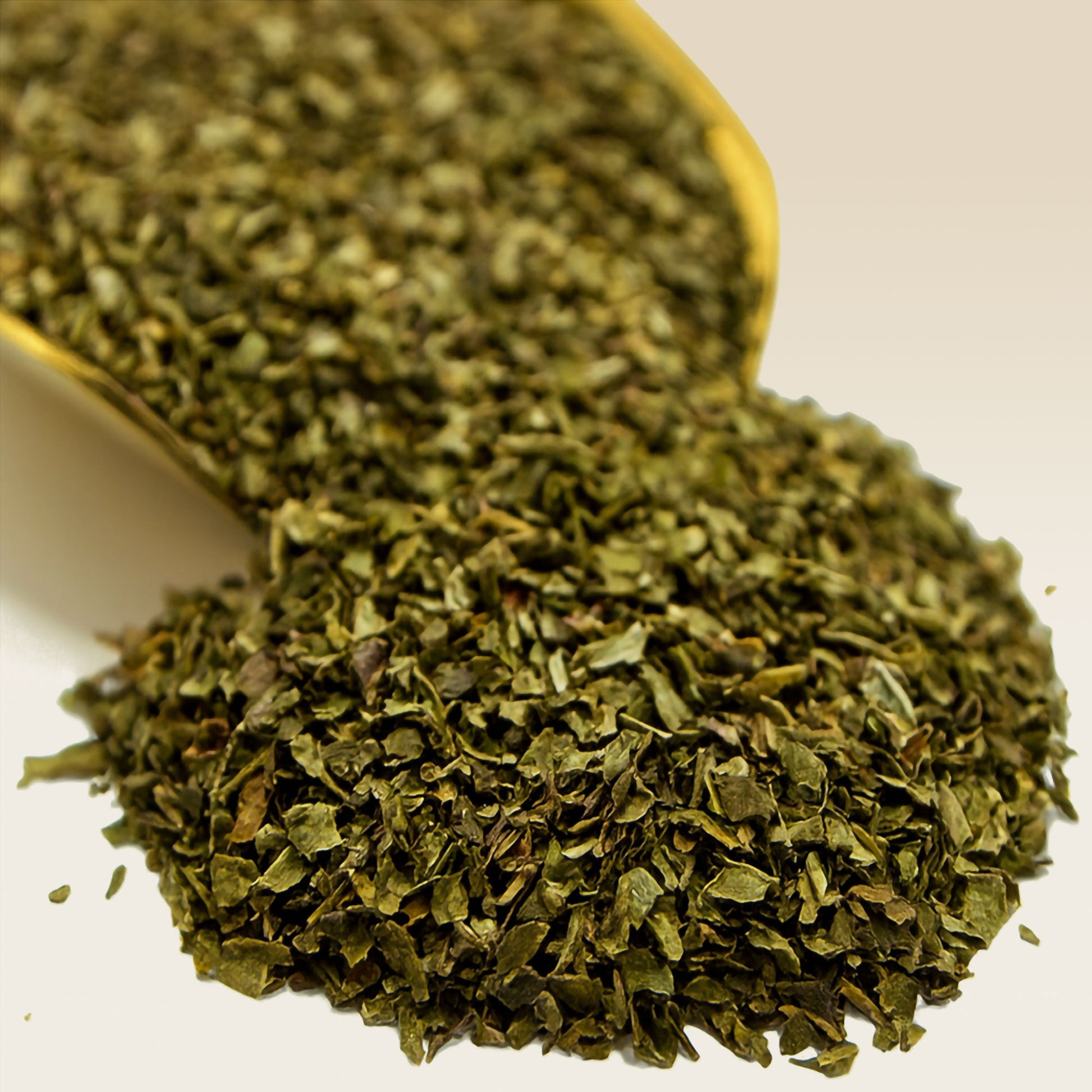 Close-up of dried Spearmint in a spoon on a white background