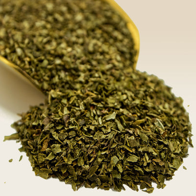 Close-up of dried Spearmint in a spoon on a white background